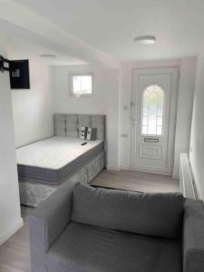 a living room with a bed and a couch at Cosy Studio Flat-Just Renovated-Free Parking & Independent Entrance in Hanworth