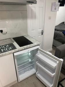 an empty refrigerator with its door open in a kitchen at Cosy Studio Flat-Just Renovated-Free Parking & Independent Entrance in Hanworth
