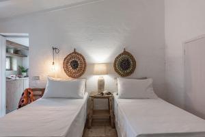 dwa łóżka siedzące obok siebie w pokoju w obiekcie Trulli-Mestandrea al poggio piscina uso esclusivo w mieście Noci