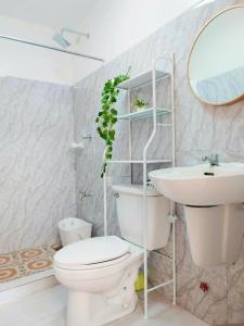 uma casa de banho com um WC, um lavatório e um espelho. em Chateau Elysee Staycation Paranaque, Metro Manila em Manila