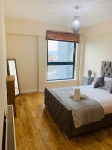 Un dormitorio con una cama grande y una ventana en Modern 2 Bed Apartment, Close to Gla Airport & M8 en Paisley