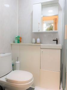 een badkamer met een toilet, een wastafel en een spiegel bij Comfortable 4 bed Apt in Paisley Next to Station in Paisley