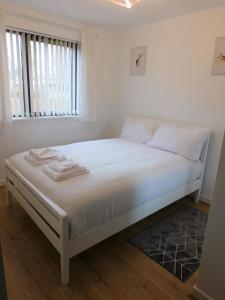 Cama blanca en habitación con ventana en 2 bed Apt on Quiet Cul-de-Sac, Fab Location, en Paisley