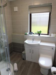 a bathroom with a sink and a toilet and a window at 2 bed Apt on Quiet Cul-de-Sac, Fab Location in Paisley