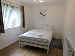 Cama pequeña en habitación con ventana en 2 bed Apt on Quiet Cul-de-Sac, Fab Location en Paisley