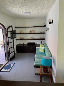 a living room with a couch and a shelf at Hostel Vila dos Corais in Arraial do Cabo
