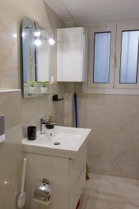 een witte badkamer met een wastafel en een spiegel bij Moon Haven Near Acropolis in Athene
