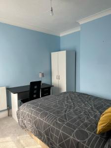 a bedroom with a bed and a desk at Eva Suites in Gillingham