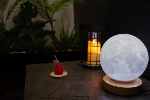 un orbe iluminado sentado en una mesa con una vela en Moon Haven Near Acropolis with 100Mbps WiFi, en Atenas 33 fotos más