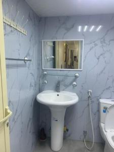 een badkamer met een wastafel, een spiegel en een toilet bij Noor Farm Stay 5BHK in Khor Fakkan