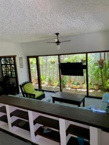 a living room with a table and chairs and windows at Hostel Vila dos Corais in Arraial do Cabo