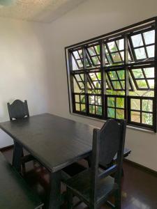 a dining room with a wooden table and two chairs at Hostel Vila dos Corais in Arraial do Cabo