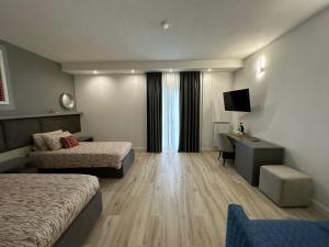 a hotel room with two beds and a desk at Evergreen Laguna Vain-Lezhe in Lezhë