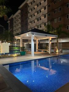 uma piscina em frente a um edifício à noite em Athena's Place - Hope Residences SMDC Trece Cavite em Trece Martires