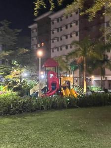 um parque infantil à noite com um equipamento de brincar em Athena's Place - Hope Residences SMDC Trece Cavite em Trece Martires