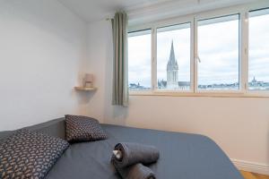 Schlafzimmer mit einem Bett und Blick auf einen Turm in der Unterkunft Appt premium Centre Château terrasse 2 chambres 6p vue exceptionnelle in Caen