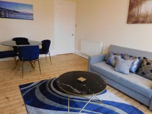 a living room with a couch and a table at Beautiful & spacious 2 bed apt in Glasgow West End in Glasgow