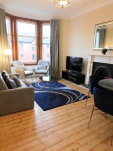 sala de estar con sofá, sillas y chimenea en Beautiful & spacious 2 bed apt in Glasgow West End, en Glasgow
