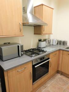 a kitchen with a stove and a microwave at Beautiful & spacious 2 bed apt in Glasgow West End in Glasgow
