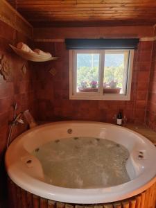 a large bath tub in a bathroom with a window at בוסתן החורש- חיפה 