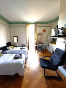 a hotel room with two beds and a chair at Chez Anna in Aix-les-Bains