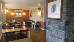 a restaurant with a brick wall and tables and chairs at The Ashville Bed and Breakfast in Bristol