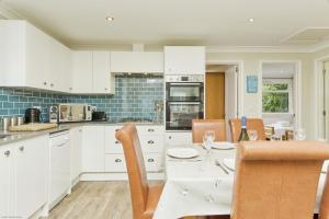 a kitchen with white cabinets and a table and chairs at Jamestown 2 in Yarmouth