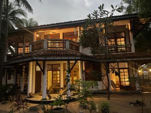 a house with a balcony on the side of it at Garden Family Appartement with Terrace Villa Wonne Beachhouse in Arugam Bay