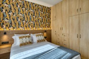 a bedroom with a bed with a painting on the wall at Deluxe Seaside Condo for 4 in Kandia