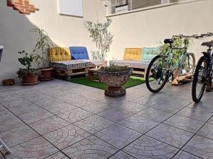een fiets geparkeerd op een patio met een bank en een bank bij Villa au cœur de la station - 1540 in Soulac-sur-Mer