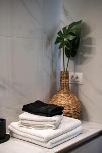 una pila de toallas en un estante con un jarrón en Deluxe Seaside Condo for 4, en Kandia