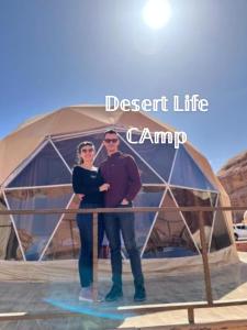a man and woman standing in front of a tent at Desert Life Camp in Wadi Rum