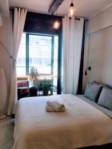 una camera da letto con un grande letto e un asciugamano di 4U SuperCentral,seaside,cosy family apartment a Salonicco