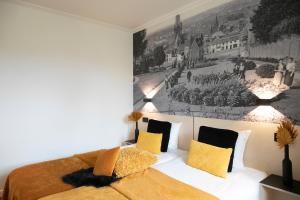 a bedroom with a bed and a painting on the wall at Hotel Grupello in Geraardsbergen