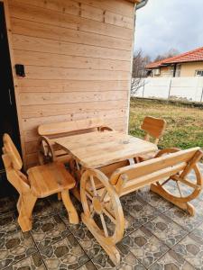 a wooden picnic table and bench next to a shed at Homoljski Raj Banja Zdrelo in Ždrelo