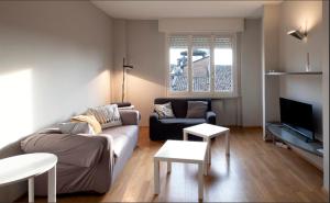 ein Wohnzimmer mit einem Sofa und einem TV in der Unterkunft Borgo di Parma in Parma