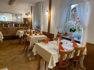 a restaurant with white tables and chairs and a window at Hotel 7 Winden in Spaichingen