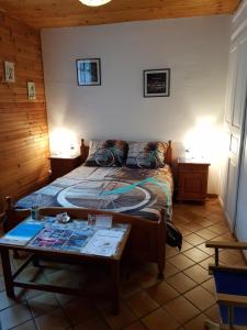 Un dormitorio con una cama y una mesa. en Au Grand Sapin Chambres chez l'habitant, en Hénonville