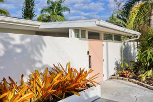 una casa bianca con cancello e piante di Modern Oasis a Sarasota