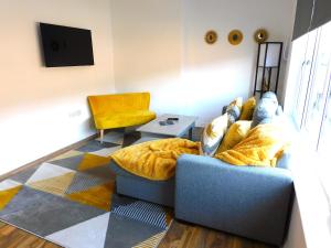 sala de estar con sofá y silla en Newly refurbished 2 bedroom apartment close to station and local amenities en Hamilton
