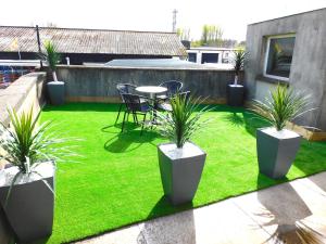 a patio with a table and chairs and grass at Newly refurbished 2 bedroom apartment close to station and local amenities in Hamilton