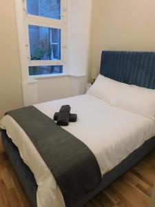 a bedroom with a bed with a hat on it at Beautiful 3 bed apt in the City Centre in Glasgow