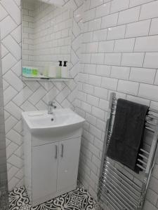 a white bathroom with a sink and a mirror at Beautiful 3 bed apt in the City Centre in Glasgow