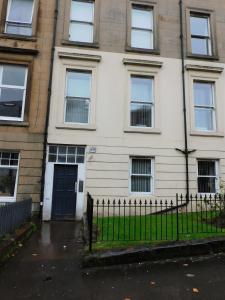 a white house with a black door and a fence at Beautiful 3 bed apt in the City Centre in Glasgow