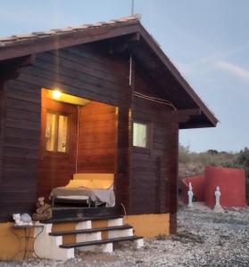 eine kleine Holzhütte mit einem Bett darin in der Unterkunft Casa La Colina Mandarina I in Tahal
