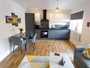 a kitchen and living room with a table and a couch at Newly refurbished 1 bed Apt in Hamilton Close to station and local amenities in Hamilton