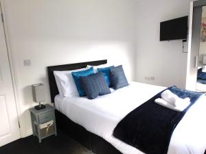 a bedroom with a large white bed with blue pillows at Newly refurbished 1 bed Apt in Hamilton Close to station and local amenities in Hamilton