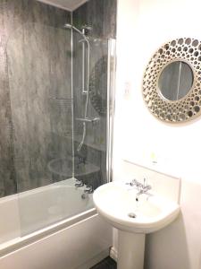 a bathroom with a sink and a shower with a mirror at Newly refurbished 1 bed Apt in Hamilton Close to station and local amenities in Hamilton