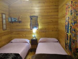 2 Betten in einem Zimmer mit Holzwänden in der Unterkunft Casa La Colina Mandarina I in Tahal