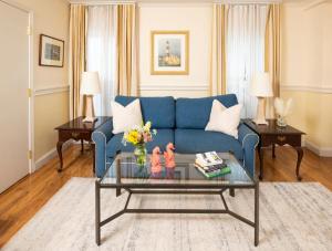 uma sala de estar com um sofá azul e uma mesa em America's Cup Inn Newport em Newport